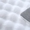 A close-up view of a white, fluffy rug with a textured, high-pile surface. The corner of the rug shows the grey backing. Anteprima dell’immagine prodotto