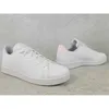 Two white Adidas Advantage sneakers with pink accents are shown on a light gray, textured background. Podgląd zdjęcia produktu