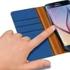 A hand is shown interacting with a blue and brown flip case for a Samsung Galaxy S6 phone. Produktbild-Vorschau