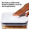 A hand presses the lid of a clear food storage container filled with oats. Náhľad obrázku produktu