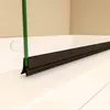 A close-up view of a shower door seal attached to a glass panel and a bathtub. Produktbild-Vorschau