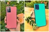 A split image showing two smartphones with different colored backings, one pink and one teal, placed in natural settings. Produktbild-Vorschau