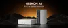 Two GEEKOM A8 mini PCs are displayed in a dark, mountainous landscape with an orange gradient sky in the background. Produktbild-Vorschau