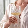 A person holding a cocktail glass filled with a golden beverage. Náhled obrázku produktu