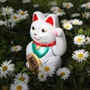 A white Maneki-neko cat figurine sits in a field of white daisies. Produktbild-Vorschau