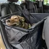 A dog is sitting in a car seat cover on the back seat of a car. Anteprima dell’immagine prodotto