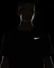 A man wearing a black Nike t-shirt with a reflective silver Nike logo. Podgląd zdjęcia produktu