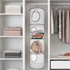 A closet interior with shelves and hanging clothes, featuring a hanging storage organizer. Produktbild-Vorschau