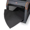 A close-up view of a gray and orange dog transport box with a black mat partially extended from the opening. Produktbild-Vorschau
