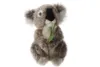 A stuffed koala toy is shown against a white background, holding a green leaf on a stem. Voir les images du produit