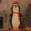 A festive indoor scene with a large, illuminated penguin decoration standing next to a decorated Christmas tree and a fireplace. Náhled obrázku produktu