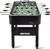 A black foosball table with green playing field and white and black player figures, shown from a front-facing, slightly elevated angle. Náhled obrázku produktu