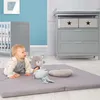A baby is playing on a mat with toys in a nursery setting. Náhled obrázku produktu
