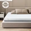 A mattress on a bed with pillows in a bedroom setting. Anteprima dell’immagine prodotto