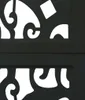 A close-up view of a black wooden screen with an intricate cutout pattern. Voir les images du produit