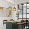 A modern dining area with pendant lights over a kitchen island and bar stools. Anteprima dell’immagine prodotto