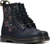A pair of black Dr. Martens boots with floral embroidery on the side, shown from a three-quarter view against a white background. Produktbild-Vorschau