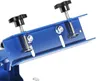 A close-up view of a blue metal clamp with black knobs, part of a screen printing machine. Podgląd zdjęcia produktu