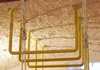 Close-up view of yellow metal bars attached to a textured ceiling, with ropes hanging down. Produktbild-Vorschau