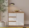 A modern sideboard with drawers and a door, placed in a room with a plant and a lamp. Voir les images du produit