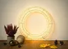 A lit wreath with decorative items on a wooden surface. Produktbild-Vorschau