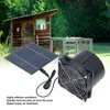 A solar-powered fan and solar panel in front of a small wooden shed. Voir les images du produit