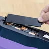 A hand is shown replacing batteries in a device. Produktbild-Vorschau
