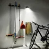 Cleaning tools and a bicycle are stored against a wall, illuminated by a spotlight. Produktbild-Vorschau