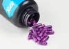 A bottle of EFX Sports Kre-Alkalyn capsules is tipped over, spilling purple capsules onto a white surface. Podgląd zdjęcia produktu
