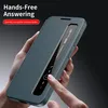 A hand is holding a teal smartphone case with a transparent window, showing a phone screen with incoming call information. Náhled obrázku produktu