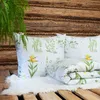 Bedding set with a floral pattern displayed on a wooden surface with a fern hanging above. Produktbild-Vorschau