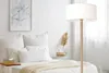A bedroom scene with a bed, pillows, and a floor lamp. Náhled obrázku produktu