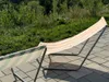 Two striped beach chairs are set up on a paved patio with a grassy area and trees in the background. Produktbild-Vorschau