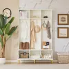 A white entryway organizer with shelves, hooks, and storage compartments, decorated with a plant, books, and accessories. Anteprima dell’immagine prodotto