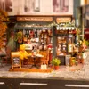 A miniature model of a bistro and bar scene, complete with a teddy bear customer. Voir les images du produit