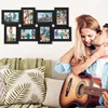 A couple is relaxing on a couch, with one person playing a guitar and kissing the other. A collage of photo frames is mounted on the wall behind them. Náhľad obrázku produktu