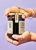 Hands holding a jar of syrup. Produktbild-Vorschau