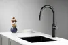 A black kitchen faucet is shown on a white countertop next to a sink. Náhľad obrázku produktu
