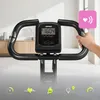 Close-up of a person's hand holding the handlebars of a stationary exercise bike, with a digital display showing workout data and icons representing fitness metrics at the bottom. Anteprima dell’immagine prodotto
