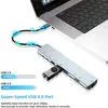 A silver USB hub adapter connected to a laptop, with a USB drive plugged into the hub. Náhled obrázku produktu