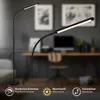 A modern LED floor lamp is shown in a home office setting, with a desk and computer in the background. The lamp is depicted in two different positions, highlighting its flexibility. Anteprima dell’immagine prodotto