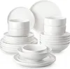 A collection of white ceramic plates and bowls stacked neatly. Produktbild-Vorschau