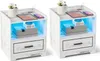 Two white distressed wood-effect nightstands with LED lighting, tablets, phones, and decorative items. Produktbild-Vorschau