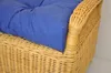 A close-up view of a blue cushion on a wicker chair. Produktbild-Vorschau