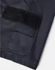 A close-up view of a dark grey work short with a black cargo pocket and a black patch on top of it. Produktbild-Vorschau