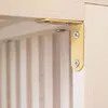 A close-up view of a golden metal bracket with screws, attached to a wooden surface. Produktbild-Vorschau