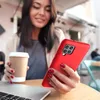 A woman holding a red phone and a coffee cup at a table with a laptop. Produktbild-Vorschau