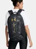 A woman wearing a white t-shirt and black leggings is seen from behind, wearing a black and gray camouflage backpack with a gold Under Armour logo. Náhled obrázku produktu