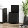 A black pedal trash can with its lid open, placed next to a potted plant and a countertop. Voir les images du produit