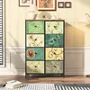 A dresser with fabric drawers is placed in a room with a lamp and artwork on the wall. Náhled obrázku produktu
